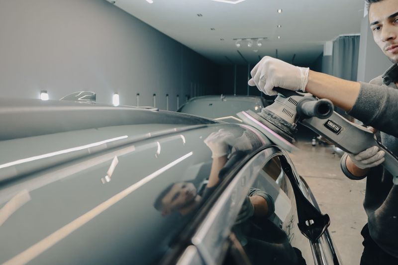 Technician performing paint correction on a vehicle in Gilbert, Arizona